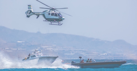 police helicopter and boat stopping drug smuggler