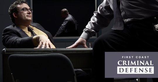 business man being interrogated in a dark room