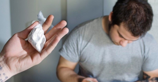 drug dealer counting money and someone holding a bag of cocaine
