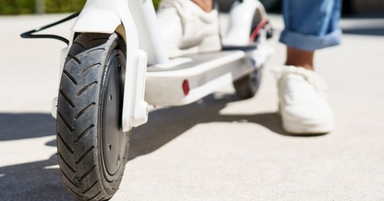 woman standing on a white electric scooter