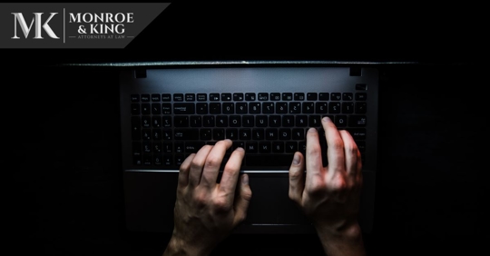 person typing on computer in a dark room, top view