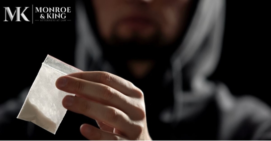 hooded man holding cocaine
